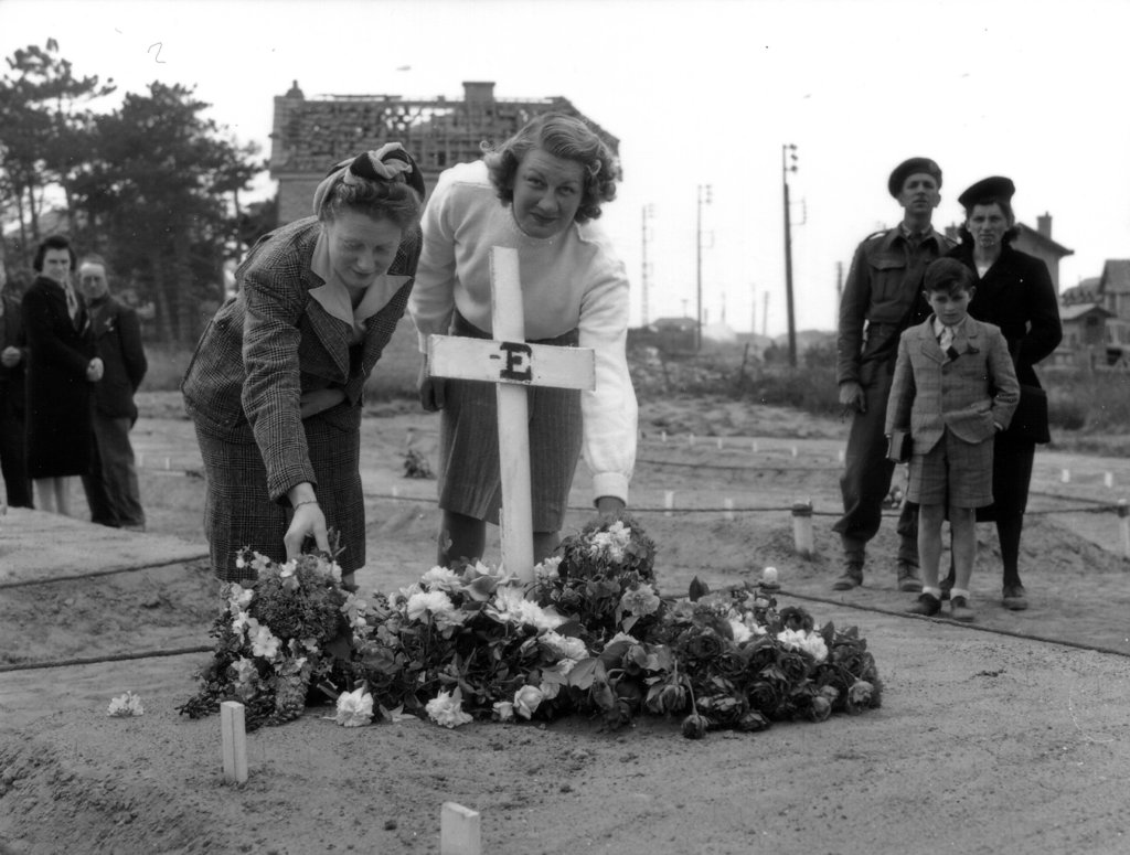 frenchwomenplacingflowersonthegraveofacanadiansoldier.jpg