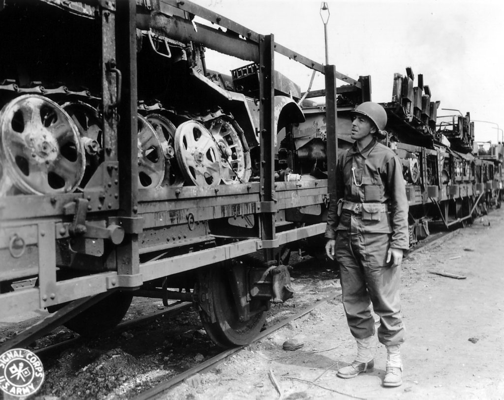 ussoldierinspectsatrainloadofgermanhalftracks.jpg